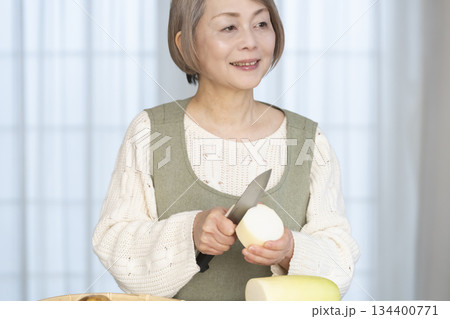 キッチンで野菜の皮を剥くシニア女性 134400771