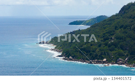 Granite coastline stretches into the distance with waves washing over rocks. Seychelles, Mahe. Granite coastline stretches into the distance with waves washing over rocks. Seychelles, Mahe. 134401572