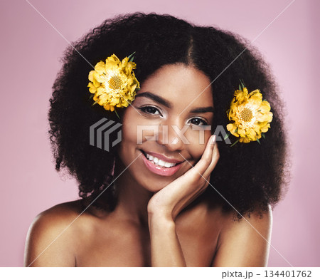 Portrait, face and happy woman with flowers in afro, studio and pink background for beauty, floral aesthetic and shine. African model, natural skincare and daisy plants in hair for organic cosmetics 134401762