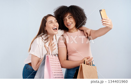 Friends, women with shopping bag and happy in selfie, retail customer and fashion isolated on studio background. Excited female people smile in picture, sale and discount with promotion at boutique Friends, women with shopping bag and happy in selfie, retail customer and fashion isolated on studio background. Excited female people smile in picture, sale and discount with promotion at boutique 134401960
