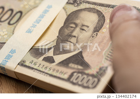 日本円一万円札の札束を扱う手元が示す金融と資金管理の概念 134402174