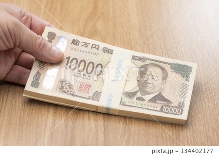 一万円札の札束を手に持つ日本円の高額資金イメージ 一万円札の札束を手に持つ日本円の高額資金イメージ 134402177