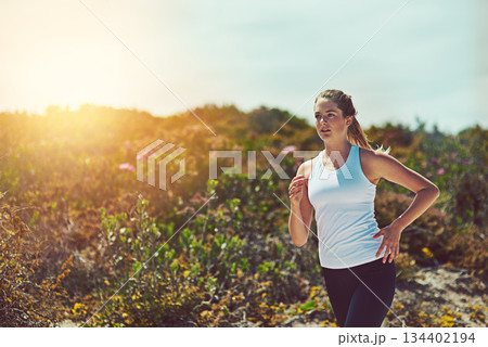 Woman running in nature, fitness outdoor with cardio and training for marathon with young athlete and sports. Female runner in bush, sunshine and run for exercise with healthy person and mockup space 134402194