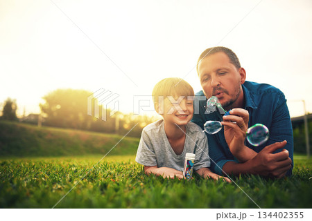 Garden, family and father and boy with bubble for quality time, bonding and having fun together. Summer, parenthood and happy dad and child blowing bubbles in park for playing, happiness and relaxing Garden, family and father and boy with bubble for quality time, bonding and having fun together. Summer, parenthood and happy dad and child blowing bubbles in park for playing, happiness and relaxing 134402355