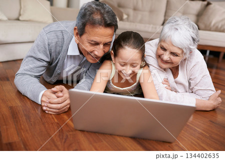 Laptop, floor or grandparents with happy child for movie streaming online subscription in retirement at home. Girl, relaxing together or grandmother watching videos on internet with a senior old man Laptop, floor or grandparents with happy child for movie streaming online subscription in retirement at home. Girl, relaxing together or grandmother watching videos on internet with a senior old man 134402635