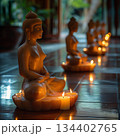 Serene evening meditation with candlelit Buddhas in a tranquil setting. Generative AI 134402765