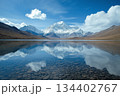Reflections of majestic mountains and clouds in crystal-clear lake under a vibrant sky. Generative AI 134402767