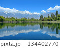Serene alpine lake reflecting majestic snow-capped mountains under a clear blue sky. Generative AI 134402770
