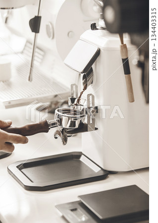 Professional Barista Skillfully Pouring Freshly Ground Coffee Into Portafilter for Espresso Preparation, Close-up Professional Barista Skillfully Pouring Freshly Ground Coffee Into Portafilter for Espresso Preparation, Close-up 134403315