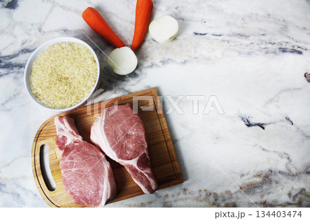 Cooking pilaf. Layout of products for pilaf Rice, meat and vegetables on the table, top view copyspace. 134403474