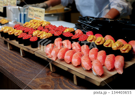 Many pieces of sushi made from salmon and unagi on the wooden tray for selling Many pieces of sushi made from salmon and unagi on the wooden tray for selling 134403655