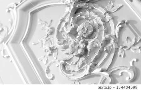 Ornate baroque-style floral wall decoration accentuated with pristine white surface Ornate baroque-style floral wall decoration accentuated with pristine white surface 134404699