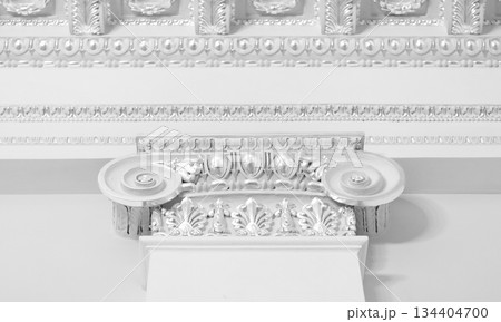 Decorative portico features of an Ionic column showcasing intricate white details 134404700