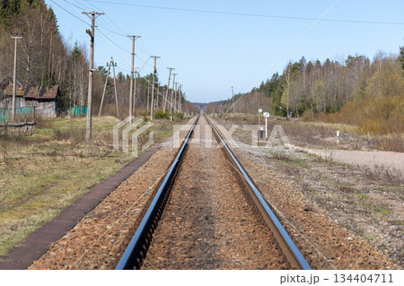A lone straight railway line runs through a quiet rural landscape A lone straight railway line runs through a quiet rural landscape 134404711