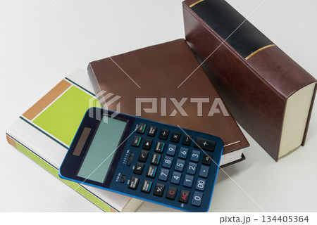 電卓とビジネス書を並べた会計と計算のイメージ 134405364