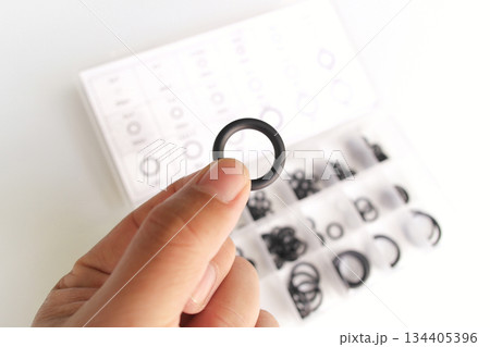 A hand holding an O-ring A hand holding an O-ring 134405396