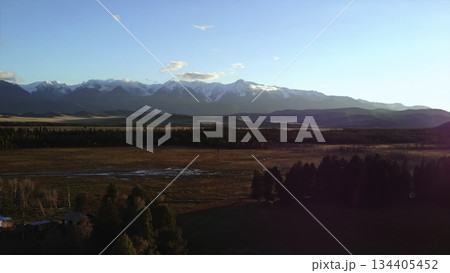 Sunlight illuminating vast wetland and majestic snow-capped mountains. Media 134405452