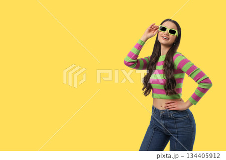 Model stands and smiles while wearing colorful outfit Model stands and smiles while wearing colorful outfit 134405912