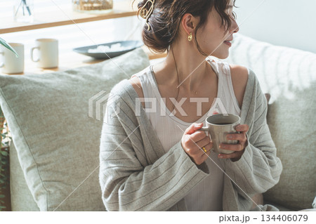 リビングでモーニングコーヒーを飲むおしゃれなアジア人女性 リビングでモーニングコーヒーを飲むおしゃれなアジア人女性 134406079