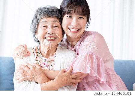 リビングでくつろぐシニアと若い女性 リビングでくつろぐシニアと若い女性 134406101