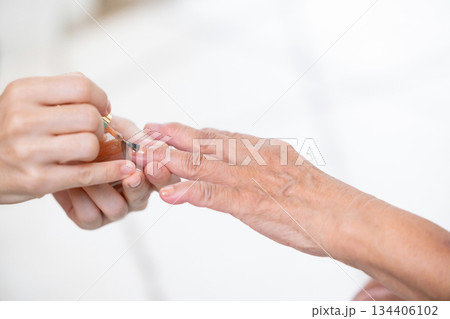 マニキュアを塗るシニア女性の手元 134406102