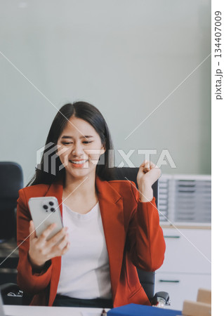 Smiling relaxed young woman sitting on couch using cell phone technology, happy lady holding smartphone, scrolling, looking at cellphone enjoying doing online ecommerce shopping in mobile apps. 134407009