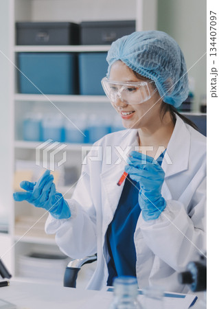 Portrait, science and happy woman on laptop in lab to research chemistry, test or innovation. Microscope, scientist and face of medical doctor in goggles for microbiology, healthcare or pharma study 134407097
