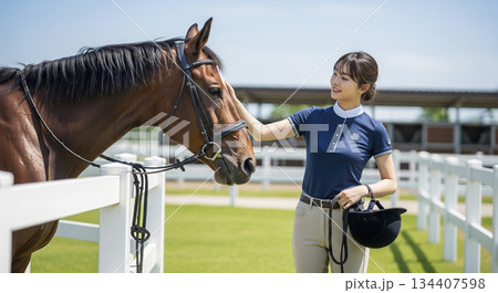 乗馬クラブで馬と触れ合っている女性 134407598
