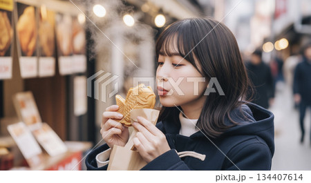 熱々のたい焼きを食べている女性 134407614