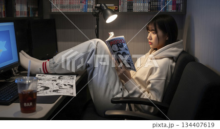 漫画喫茶の個人ブースで漫画を読んでいる女性 漫画喫茶の個人ブースで漫画を読んでいる女性 134407619