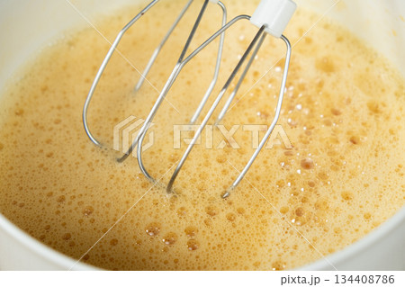 The process of beating eggs with sugar with a mixer, close-up, making the dough. The process of beating eggs with sugar with a mixer, close-up, making the dough. 134408786