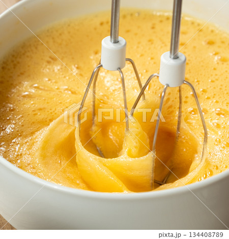 The process of beating eggs with sugar with a mixer, close-up, making the dough. The process of beating eggs with sugar with a mixer, close-up, making the dough. 134408789