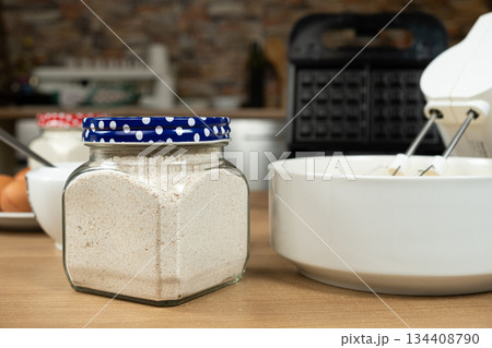 Whole wheat flour in a glass jar for making homemade healthy dough. 134408790