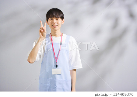 エプロンをした20代男性保育士 134409370