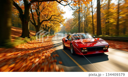 秋の紅葉を走る赤い車 134409379