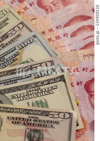 red Chinese cash in denominations of one hundred yuan and American money , a pile of paper cash of American and Chinese money , Chinese banknotes of 100 yuan 134409538