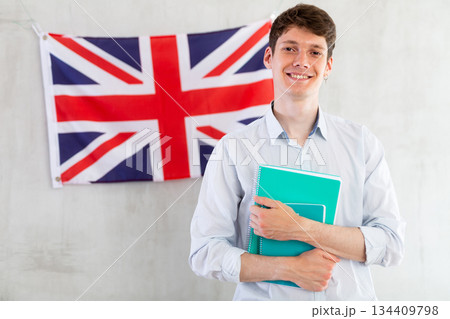 Young guy posing with notebooks against background of UK flag 134409798
