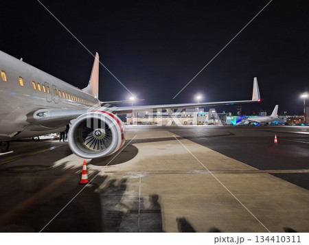 Airplane jet waiting to runway on taxi lane in airport. Night time. Airplane wing. Airplane jet waiting to runway on taxi lane in airport. Night time. Airplane wing. 134410311