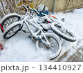 Snow covered bicycles in winter yard 134410927