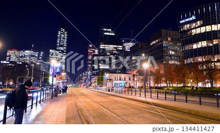 Warsaw, Poland. 4 November 2025. City life after dark. Traffic with cars passing on the street in center city in the night. Lights street and buildings towering around them. Warsaw, Poland. 4 November 2025. City life after dark. Traffic with cars passing on the street in center city in the night. Lights street and buildings towering around them. 134411427