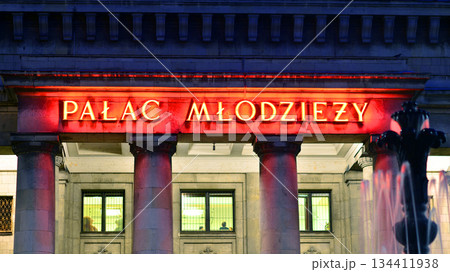 Warsaw, Poland. 4 November 2025. City life after dark. Signboard "Palac Mlodziezy". Lights street and buildings towering around them. Warsaw, Poland. 4 November 2025. City life after dark. Signboard "Palac Mlodziezy". Lights street and buildings towering around them. 134411938