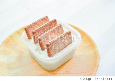 容器入ったヨーグルトにサブレを刺す 容器入ったヨーグルトにサブレを刺す 134412344