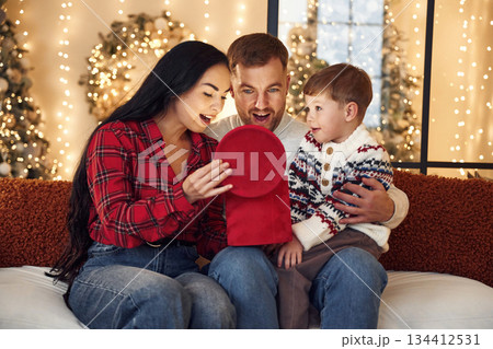 Opening up gift box. Happy family celebrating new year together at home Opening up gift box. Happy family celebrating new year together at home 134412531