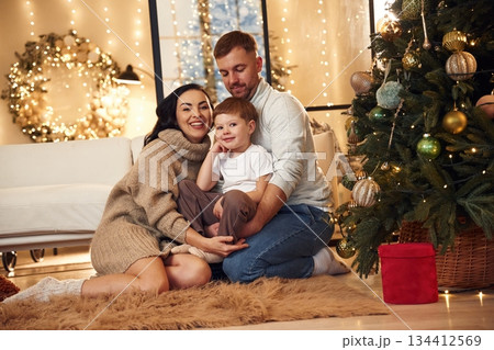 On the floor, sitting. Happy family celebrating new year together at home On the floor, sitting. Happy family celebrating new year together at home 134412569