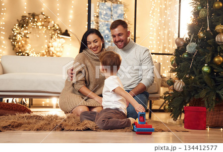 On the floor, sitting. Happy family celebrating new year together at home On the floor, sitting. Happy family celebrating new year together at home 134412577
