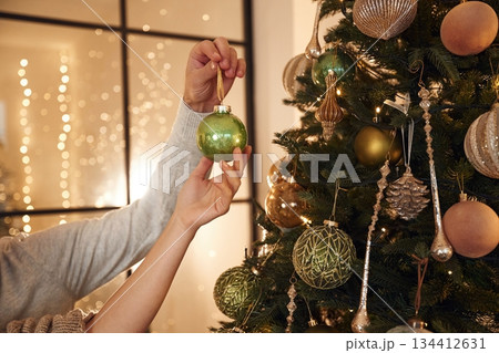 Taking care of new year decoration. Close up view of man's and woman's hands Taking care of new year decoration. Close up view of man's and woman's hands 134412631