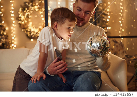 Father with his son are in new year Christmas decorated room 134412657