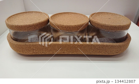 Glass spice jars with cork lids on wooden tray Glass spice jars with cork lids on wooden tray 134412807