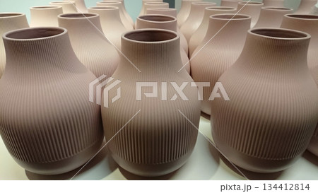 Minimalist ceramic vases arranged in repeating pattern 134412814