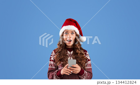 Millennial woman with cellphone shocked over huge Christmas discount in online shop, blue background. Panorama 134412824